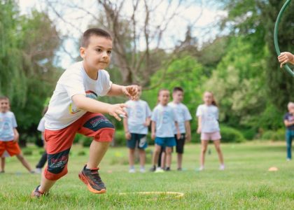 A group of children actively playing with hula hoops on a bright summer day in the park.